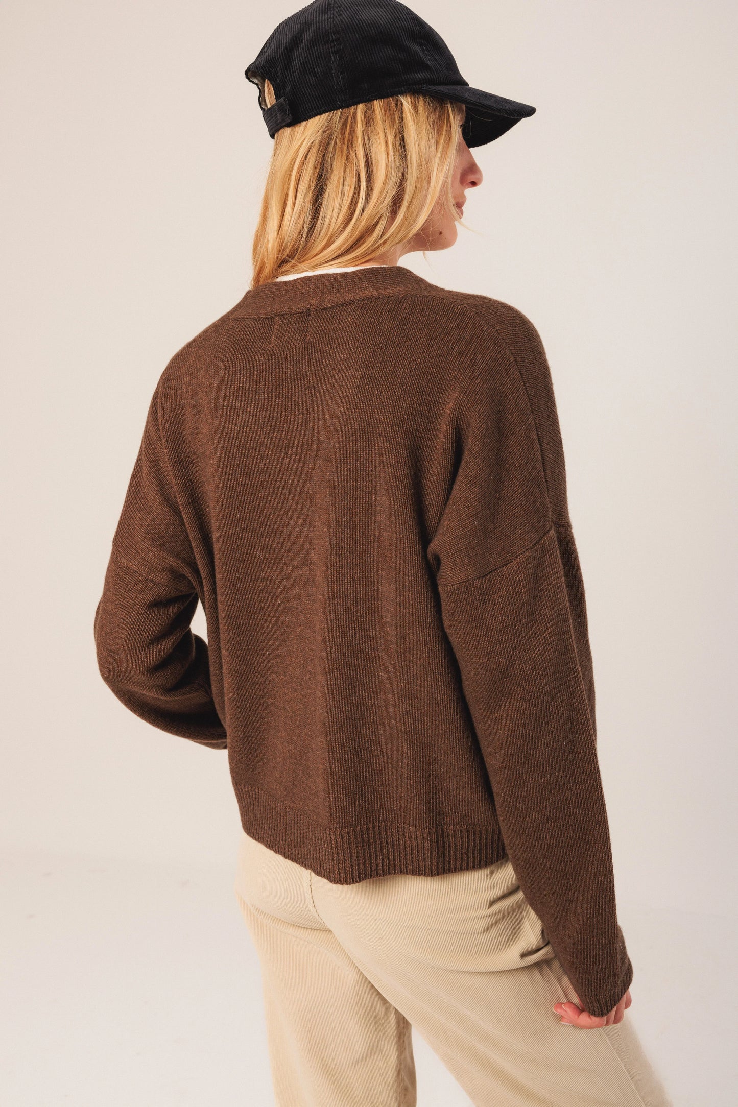 Brown ribbed knit sweater with black cap, styled with beige corduroy pants for casual women's fashion