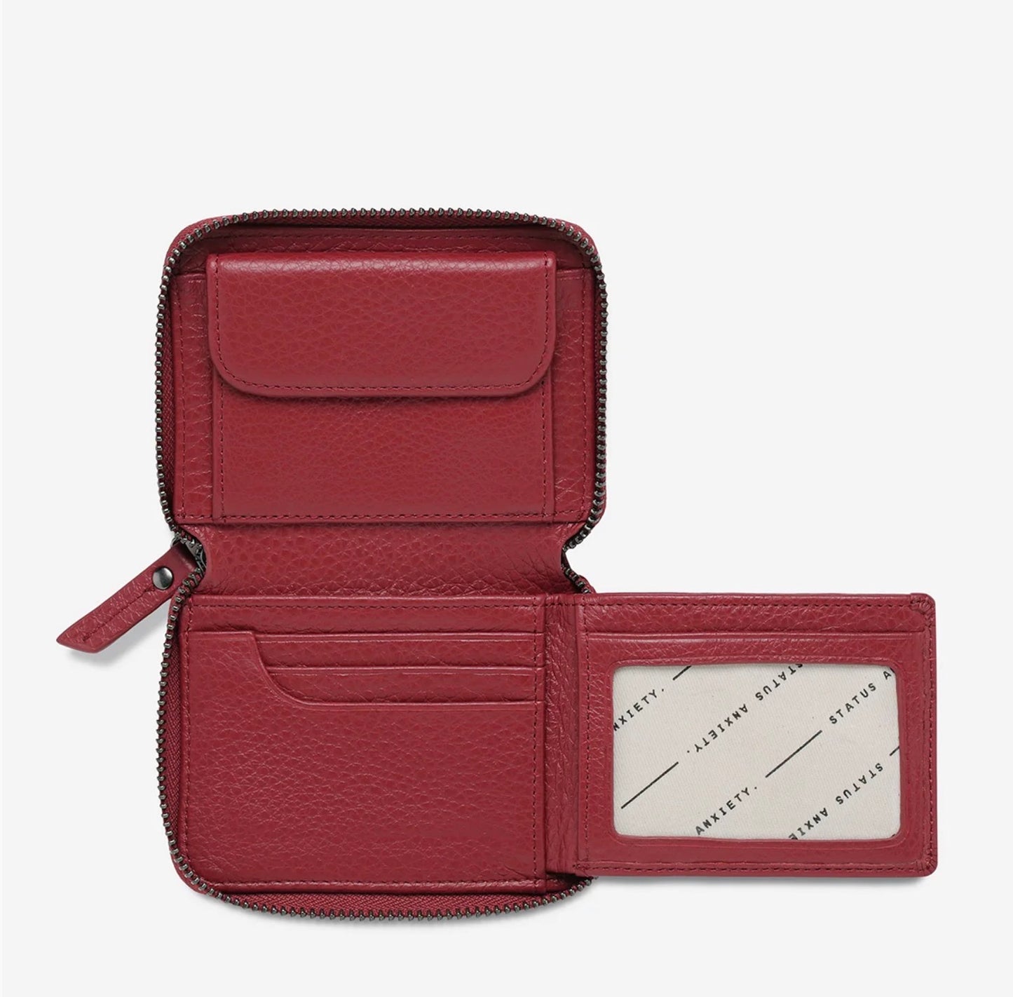 Red leather zip-around wallet with card slots and ID window, open to show interior organization