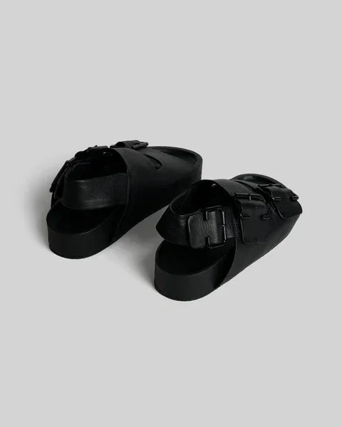 Black leather slide sandals with buckle straps, modern minimalist design for women's fashion footwear