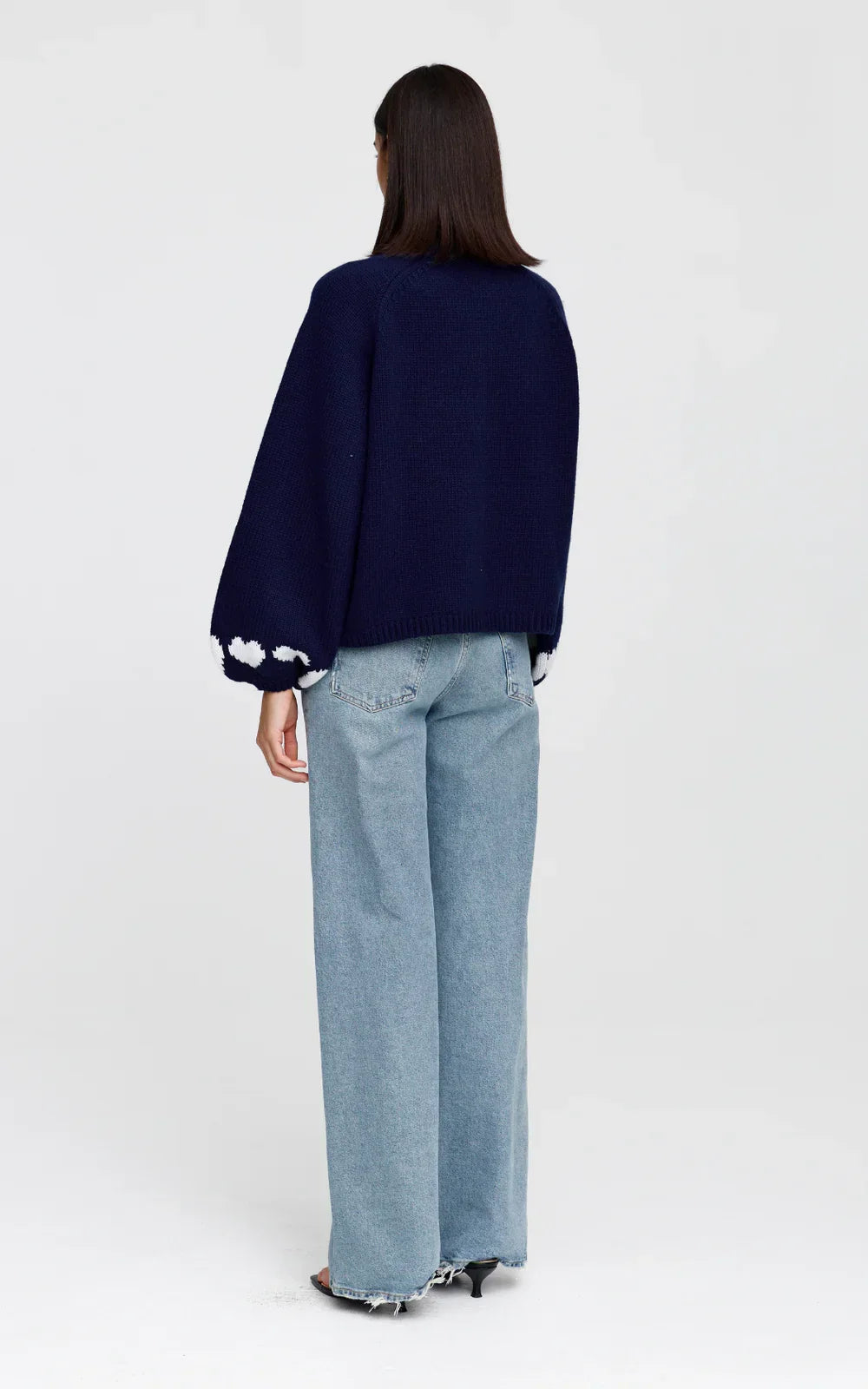 Navy blue knit cardigan with white heart trim, paired with wide-leg jeans and heels