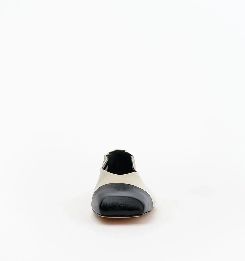 Front view of a black and beige two-tone leather flat shoe.