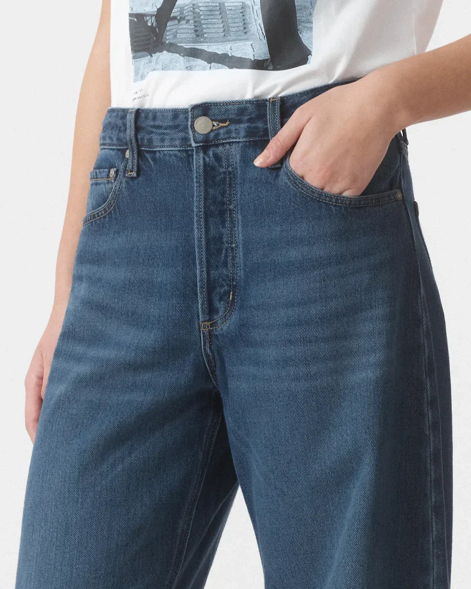 High-waisted wide-leg denim jeans with classic stitching and front pockets, styled with graphic tee