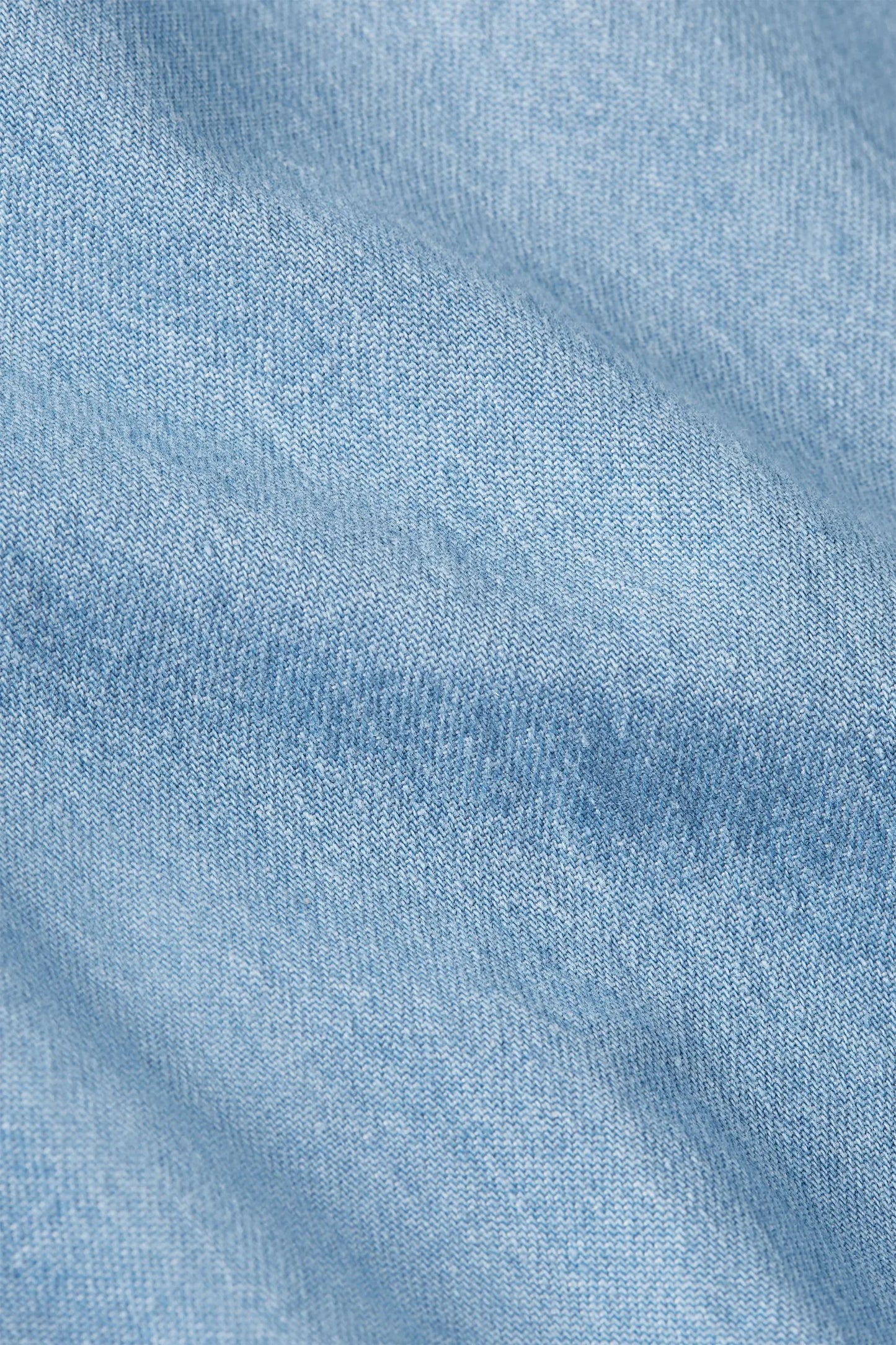 Light blue denim fabric texture with subtle weave pattern and soft folds for casual fashion wear