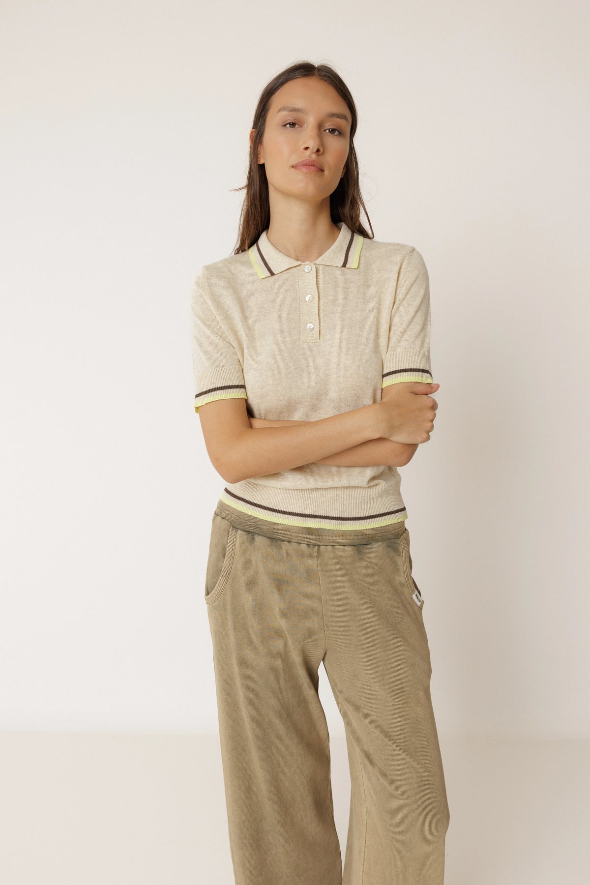 Woman wearing an INDI & COLD Contrast Stripe Knit Polo in Beige and brown trousers.