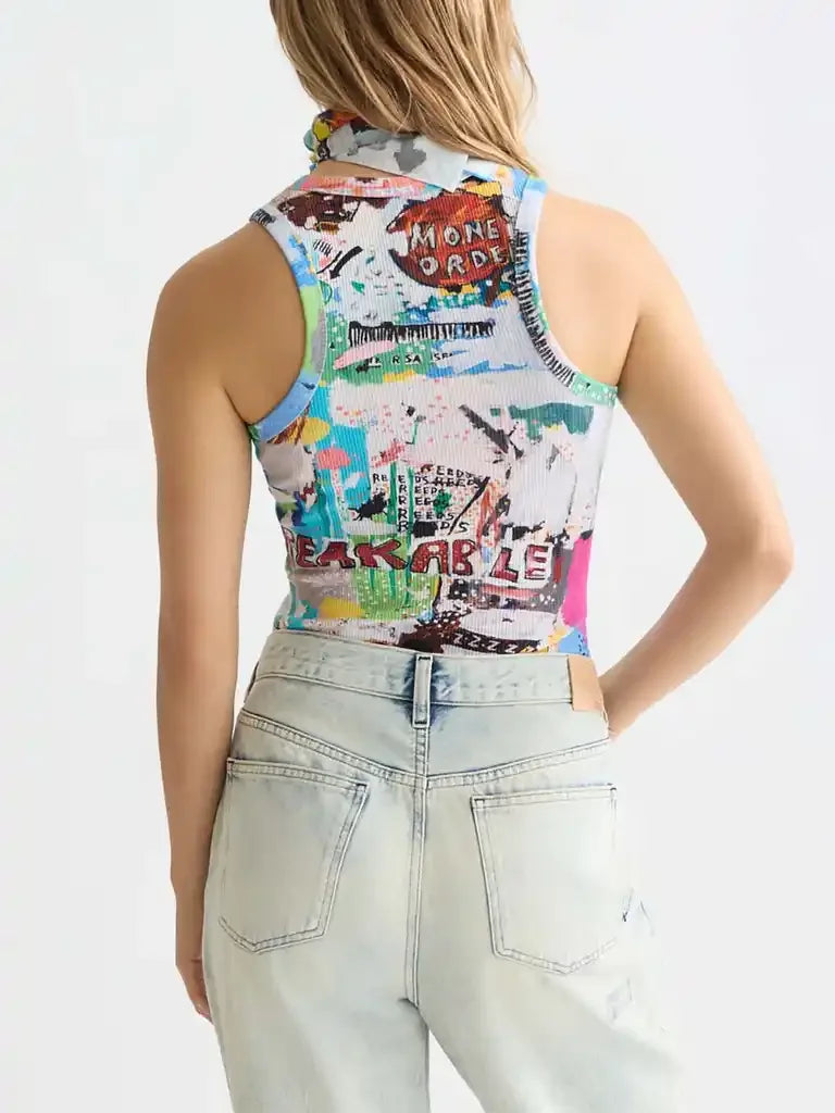 Graphic print sleeveless top with colorful graffiti-style design, paired with light wash denim jeans
