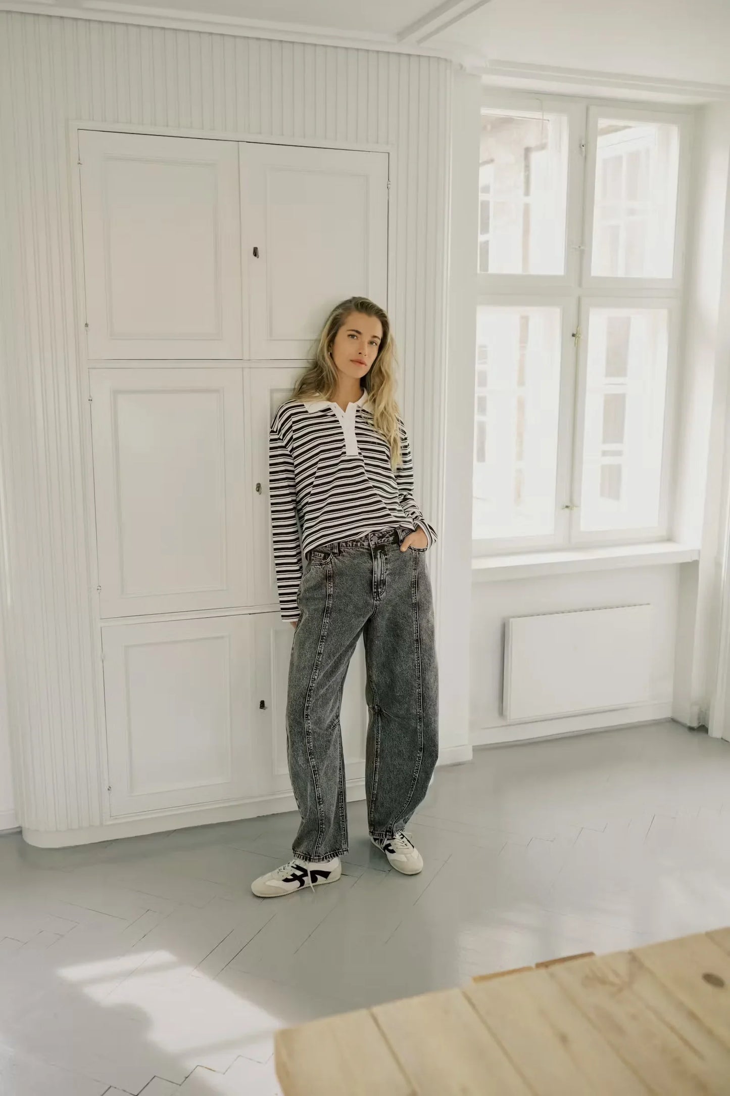 Woman in striped long sleeve polo shirt and wide leg jeans, casual fashion outfit
