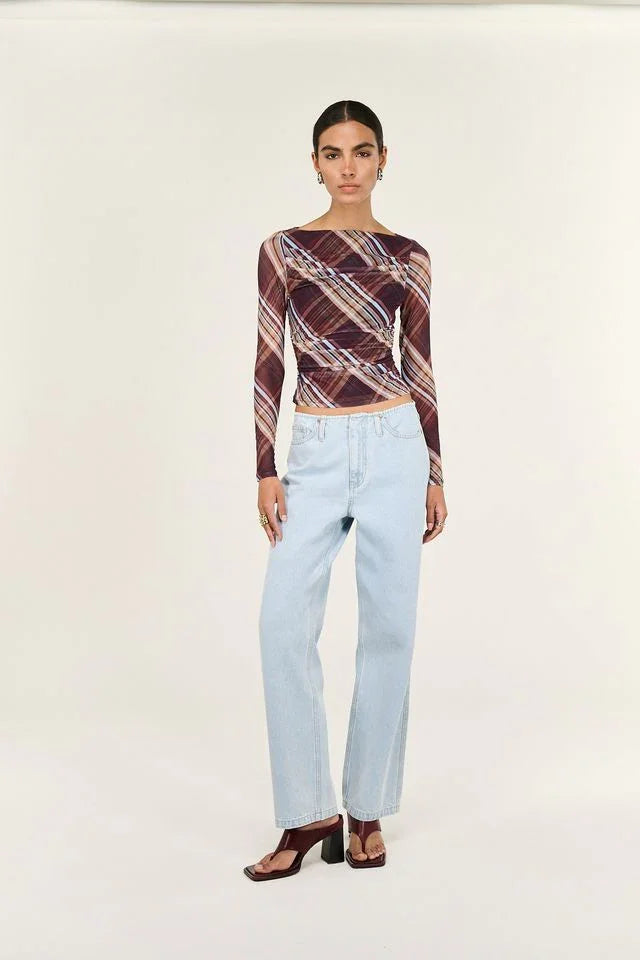 Woman wearing plaid long sleeve crop top with light wash wide leg jeans and block heel sandals