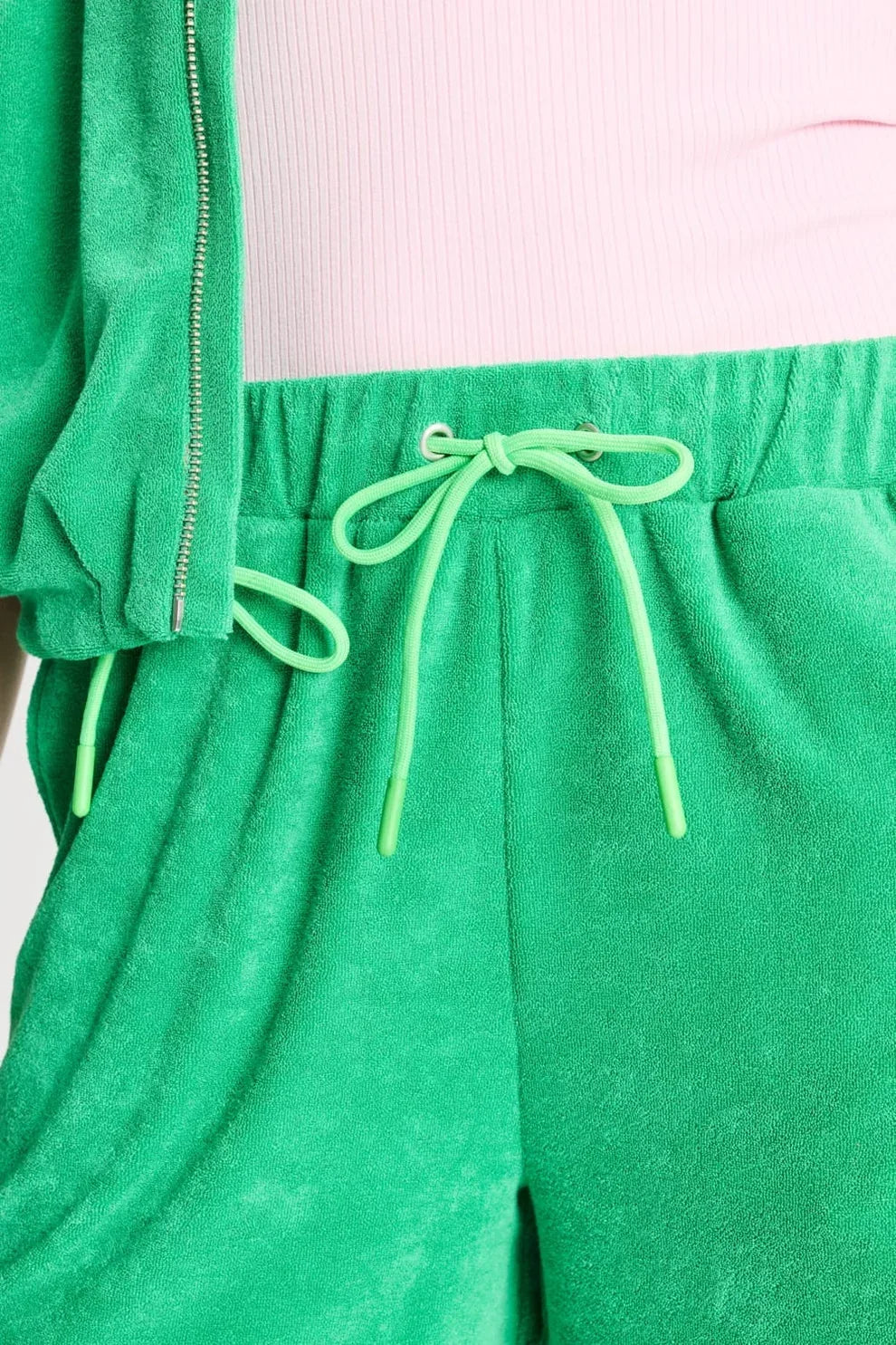 Green velvet drawstring sweatpants paired with a light pink ribbed top.
