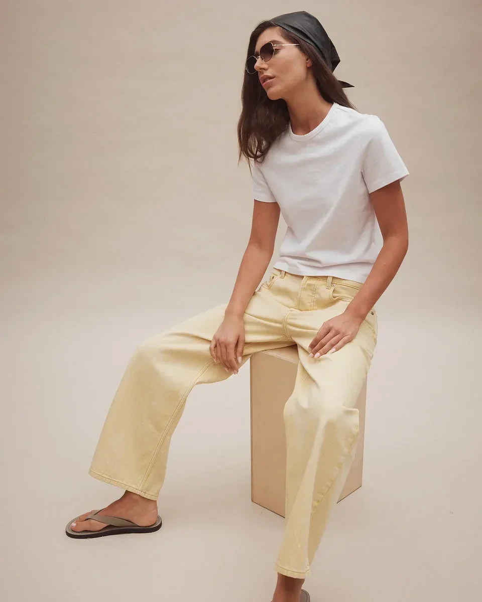 Woman wearing Nobody Denim Nadia Jean in Flax with a white t-shirt and black headscarf.