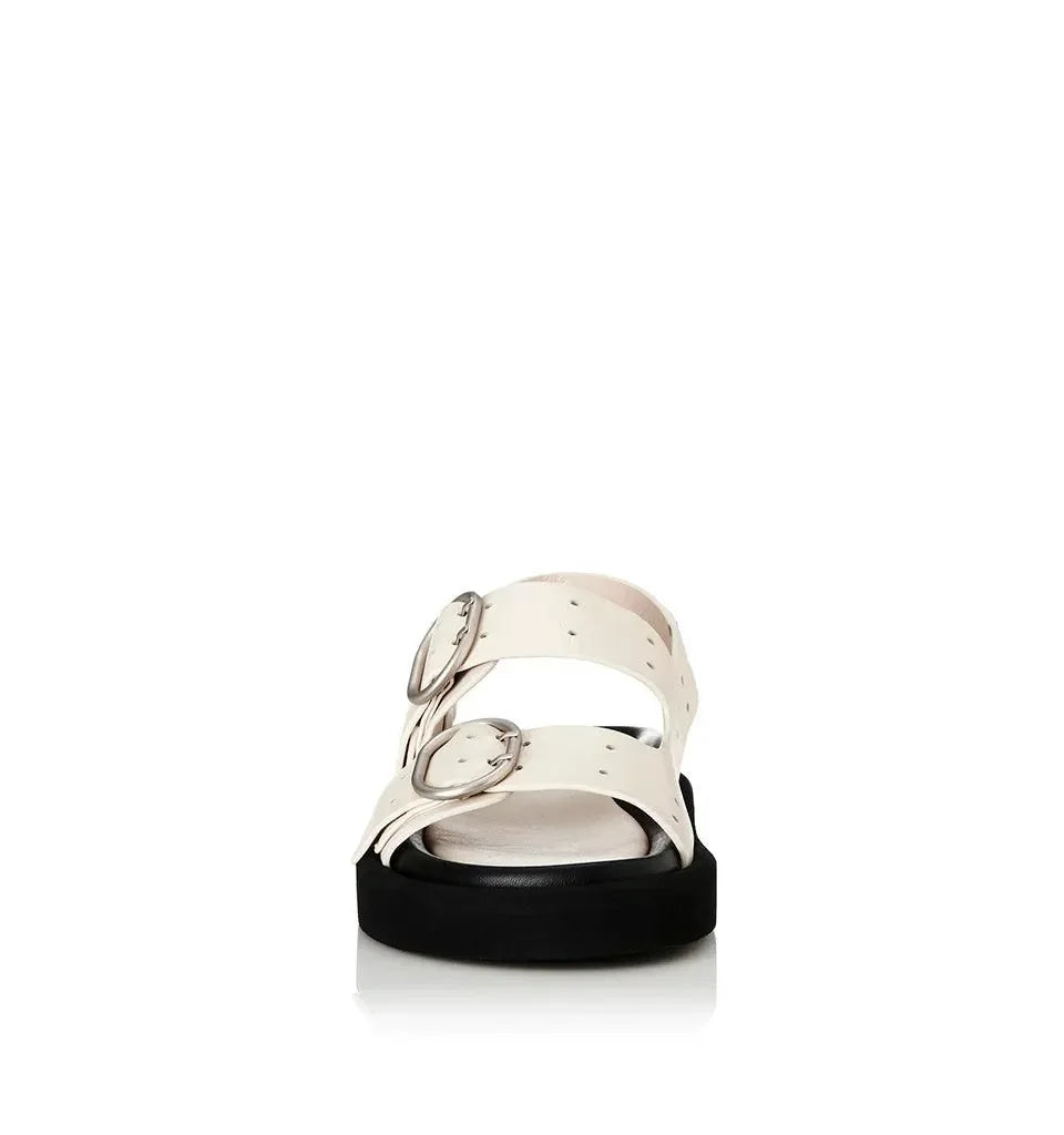 White strappy sandals with silver buckles and black platform sole