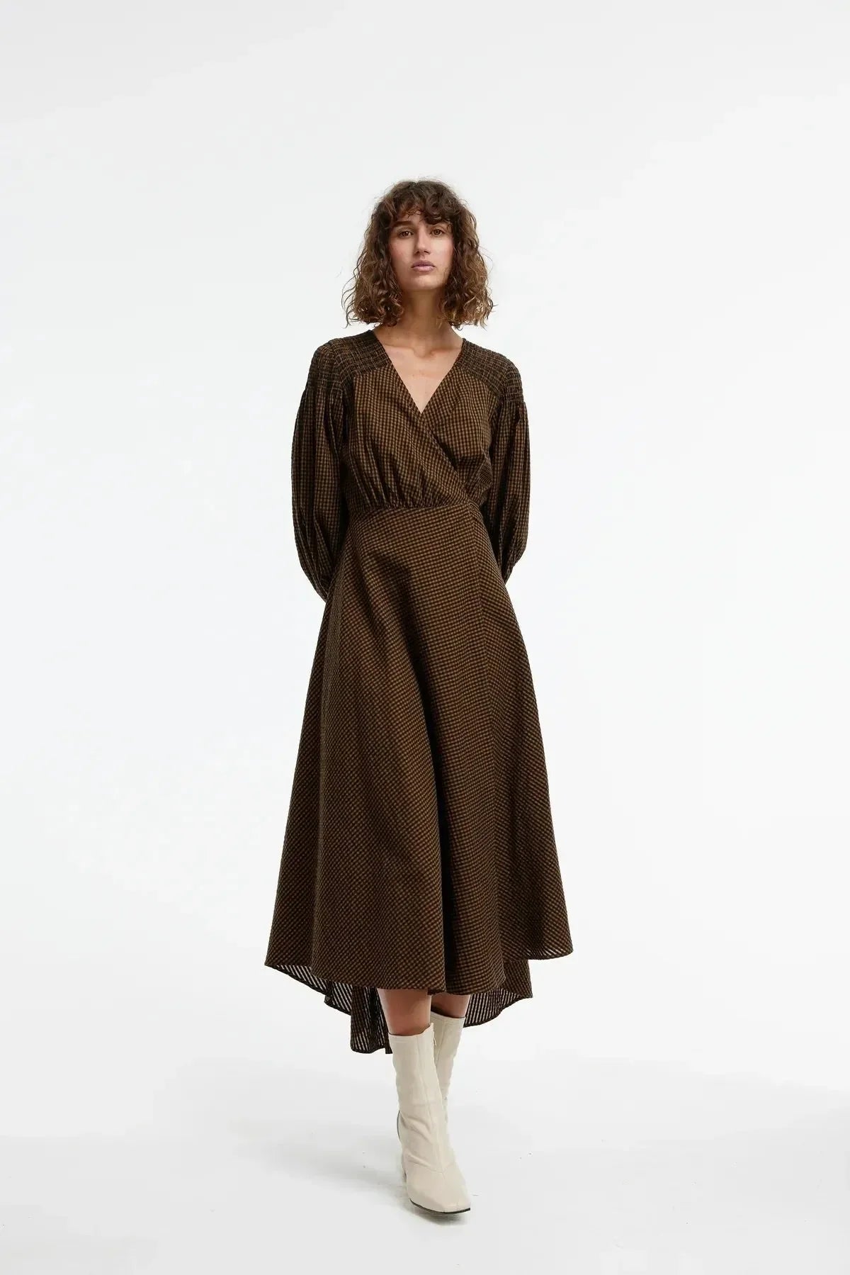 Brown checkered wrap dress with puff sleeves, paired with white boots for chic everyday style