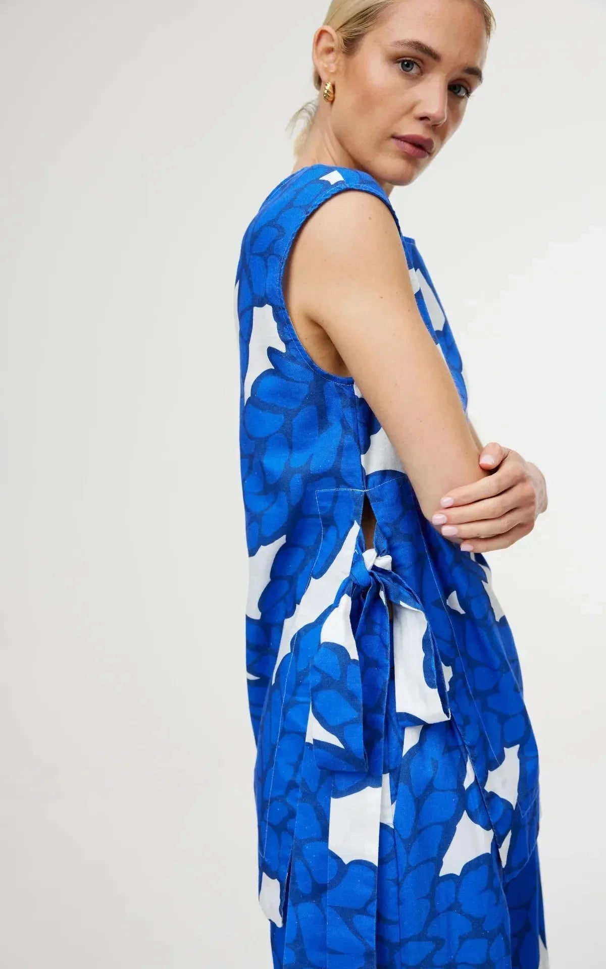 Blue and white floral print sleeveless dress with side tie detail, stylish women's fashion