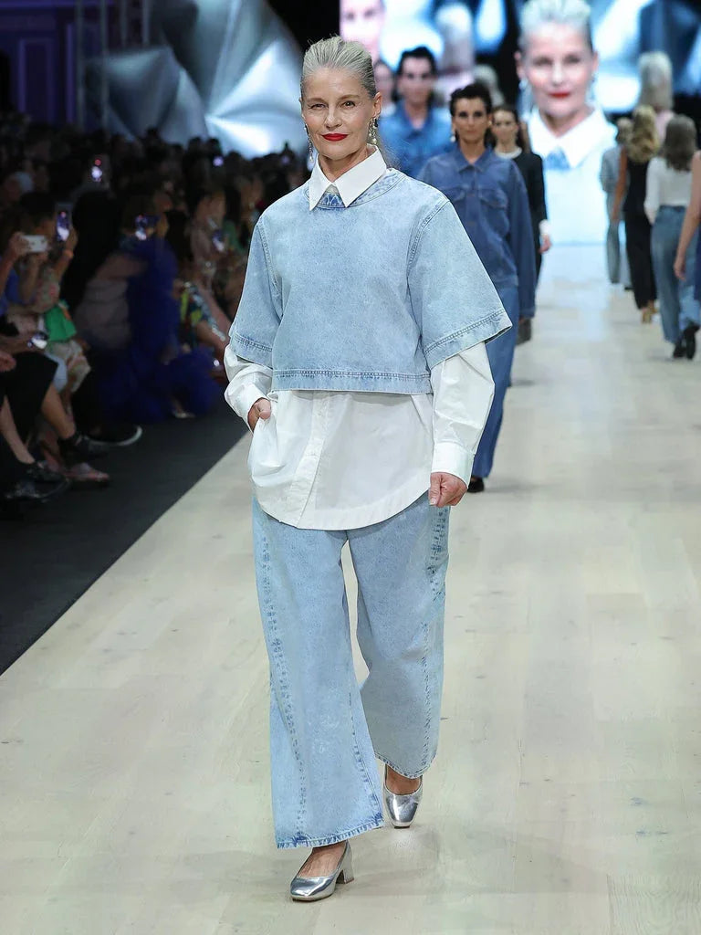 Woman in denim crop top and wide-leg jeans walking runway