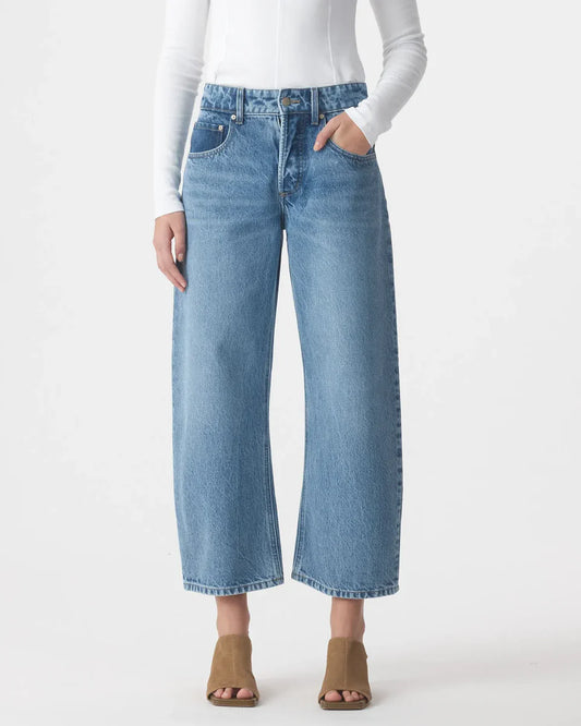 Woman wearing high-waisted wide-leg blue jeans and tan heeled sandals