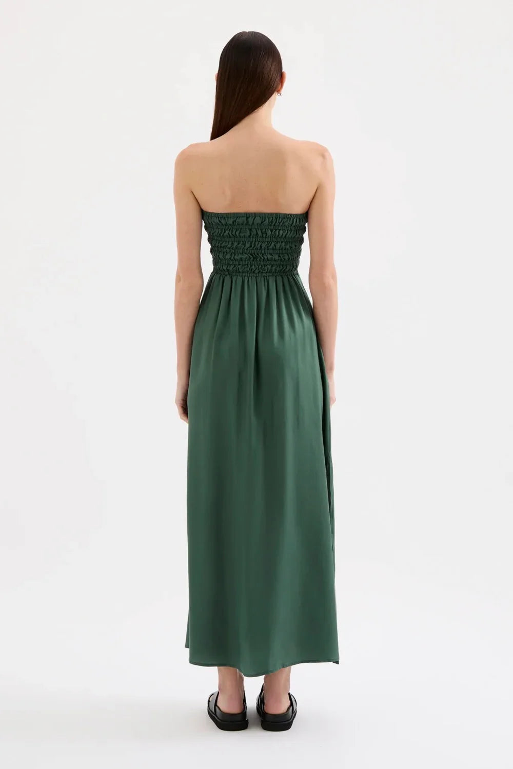 Back view of woman wearing strapless green maxi dress with shirred bodice