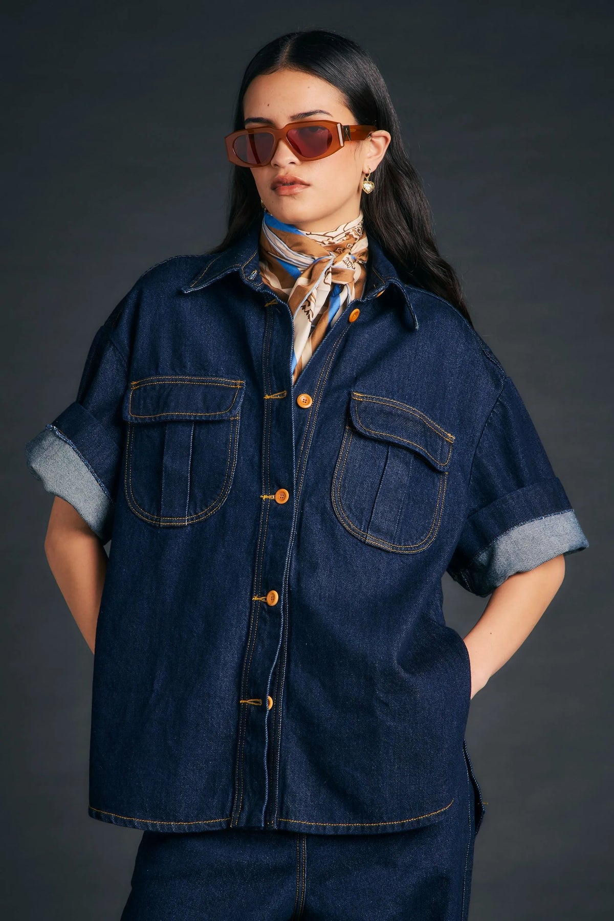 Woman wearing Outland Denim X Karen Walker Mod Shirt in indigo with a patterned scarf.