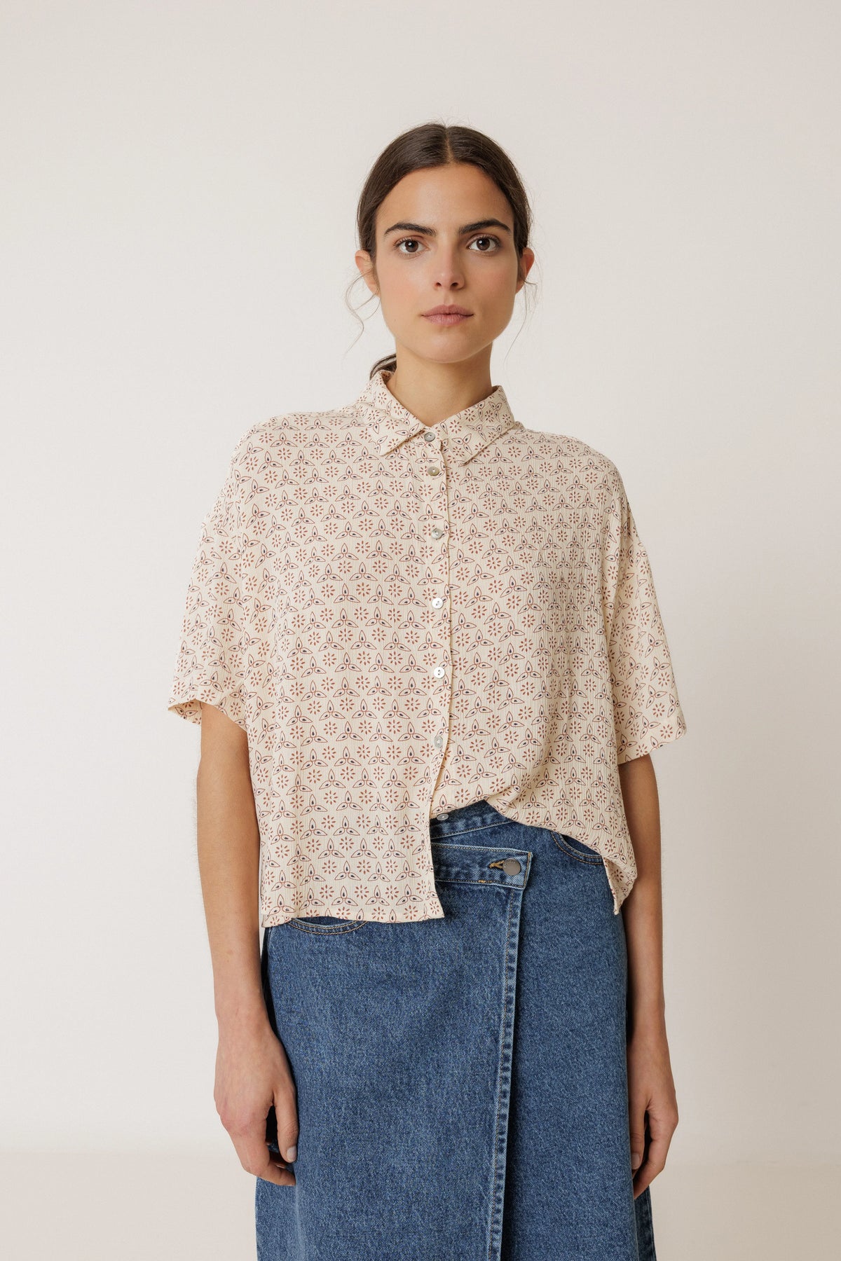 Woman wearing INDI & COLD Oversized Block Print Shirt in Crudo with a blue denim skirt.
