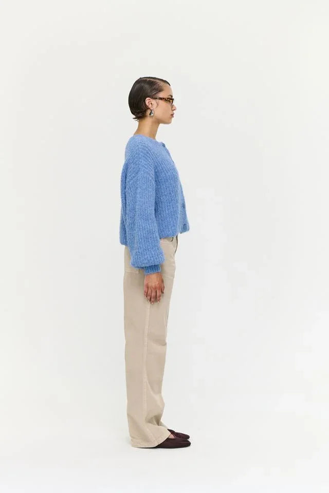 Woman in blue knit sweater and beige pants, stylish casual outfit