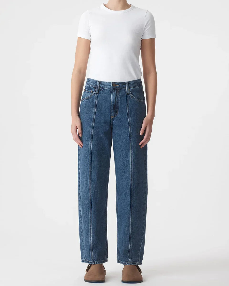 High-waisted wide-leg denim jeans paired with a white t-shirt and brown shoes