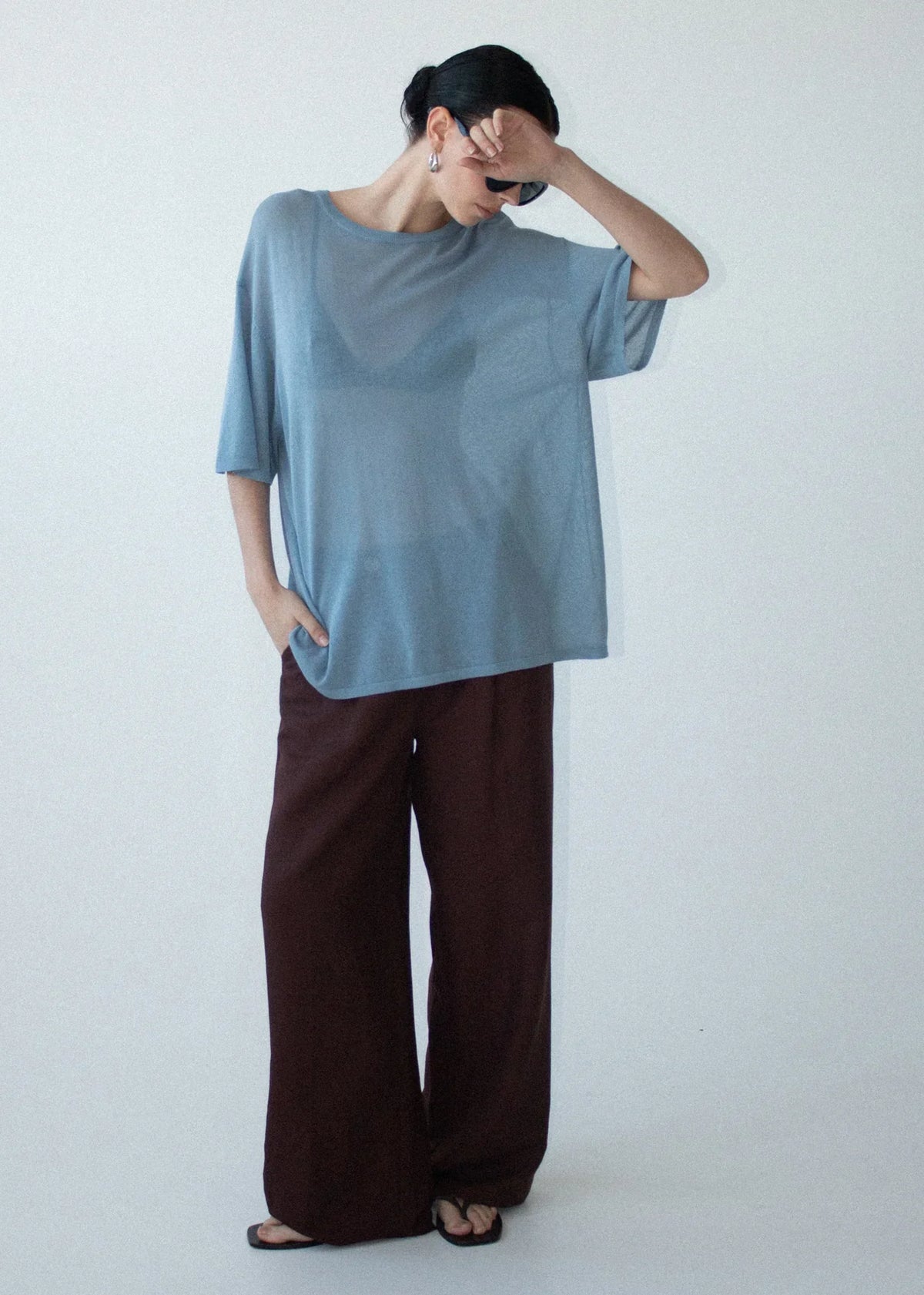 Woman wearing STAPLE THE LABEL Orla Oversized Knit Tee in Dusty Blue and brown wide-leg pants.