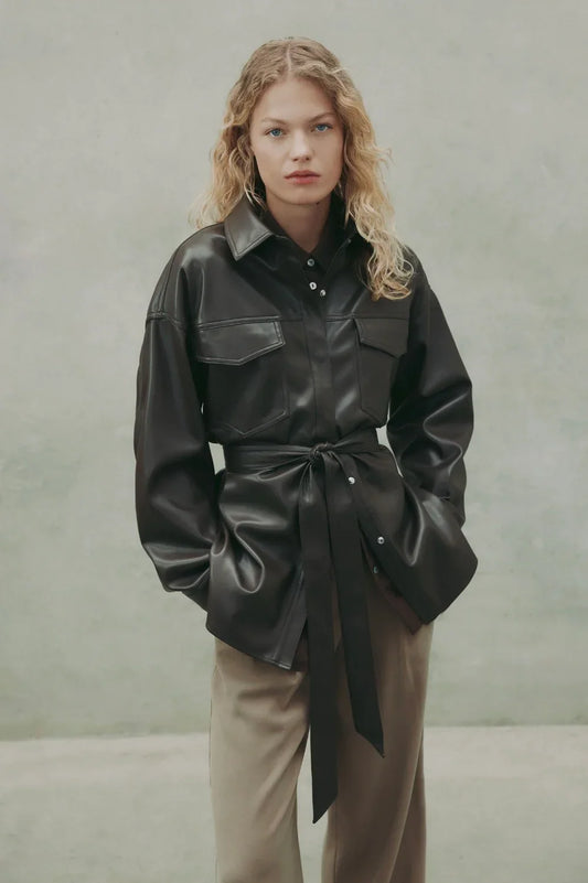 Black leather shirt jacket with belt, styled with beige pants for women's fashion