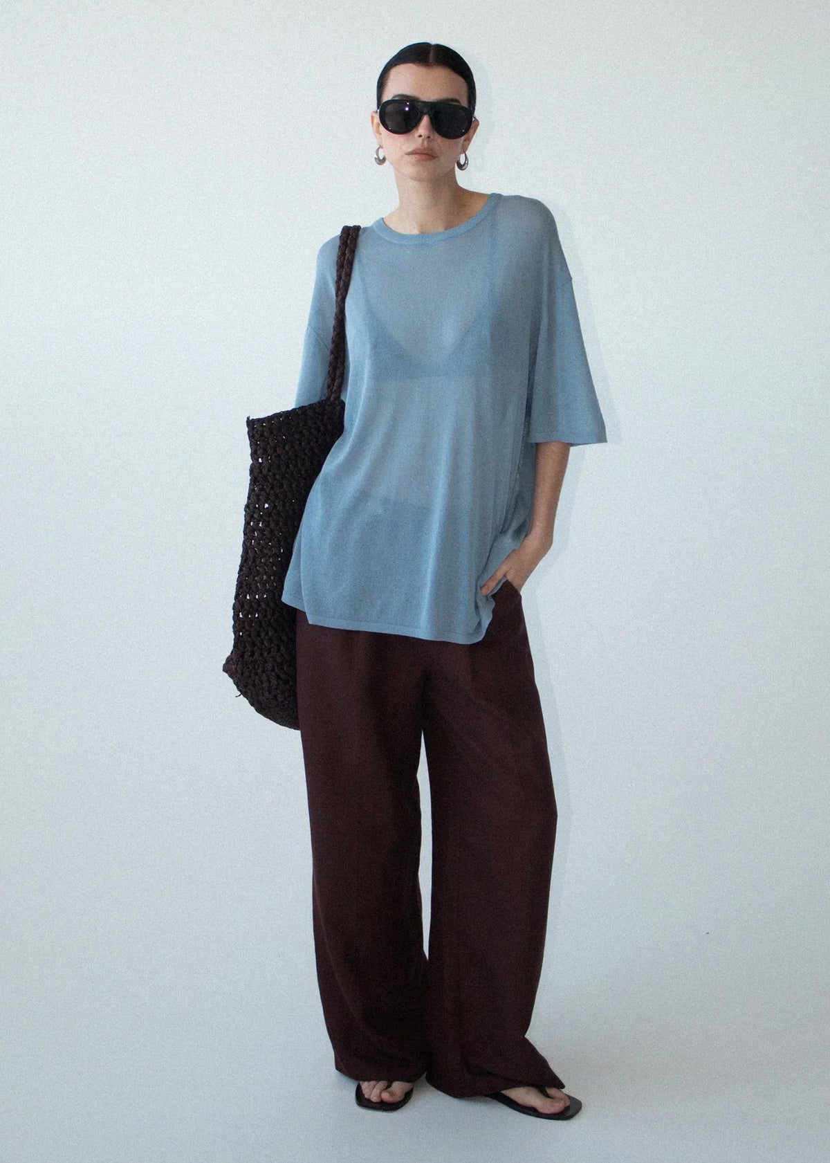 Woman wearing STAPLE THE LABEL Orla Oversized Knit Tee in Dusty Blue with brown wide-leg pants