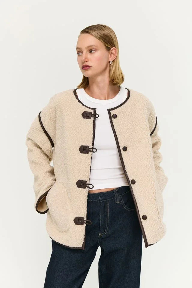 Cream shearling jacket with toggle buttons, styled with white top and dark jeans for women's fashion