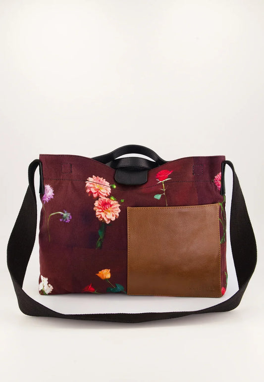 Floral print tote bag with brown leather panel and black straps, ideal for women's fashion
