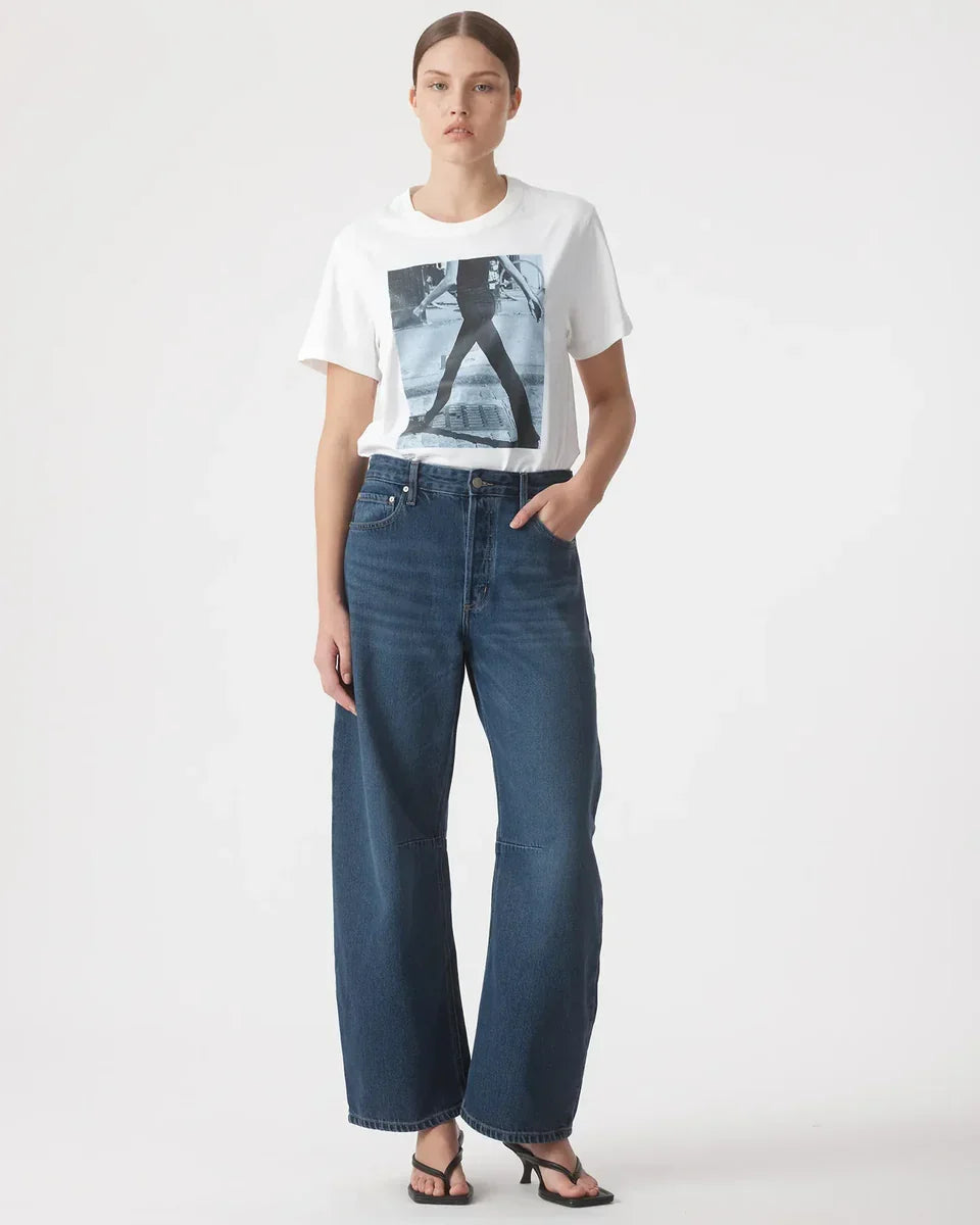 Woman in white graphic tee and wide-leg blue jeans, casual fashion outfit
