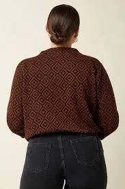 Woman wearing a brown geometric patterned sweater and black jeans, back view