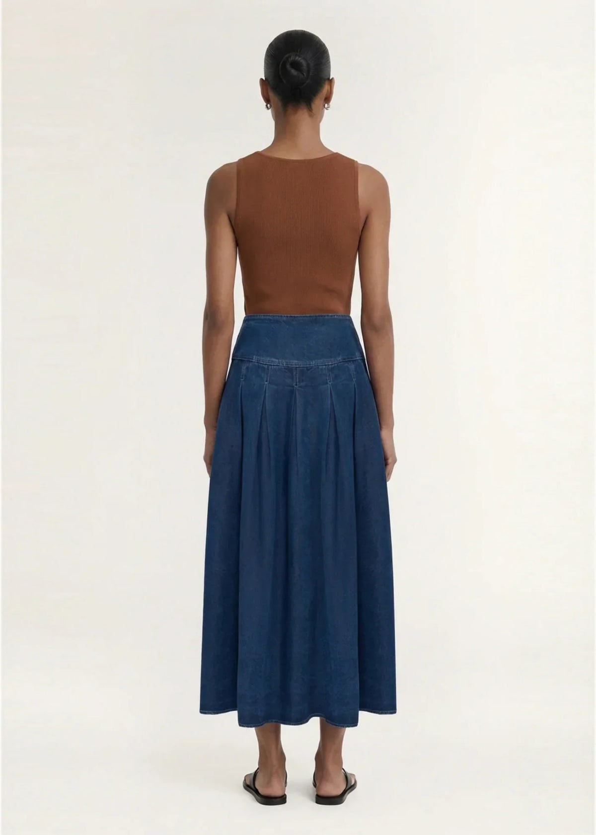 Back view of a model wearing a STAPLE THE LABEL Roma Chambray Midi Skirt and brown top.