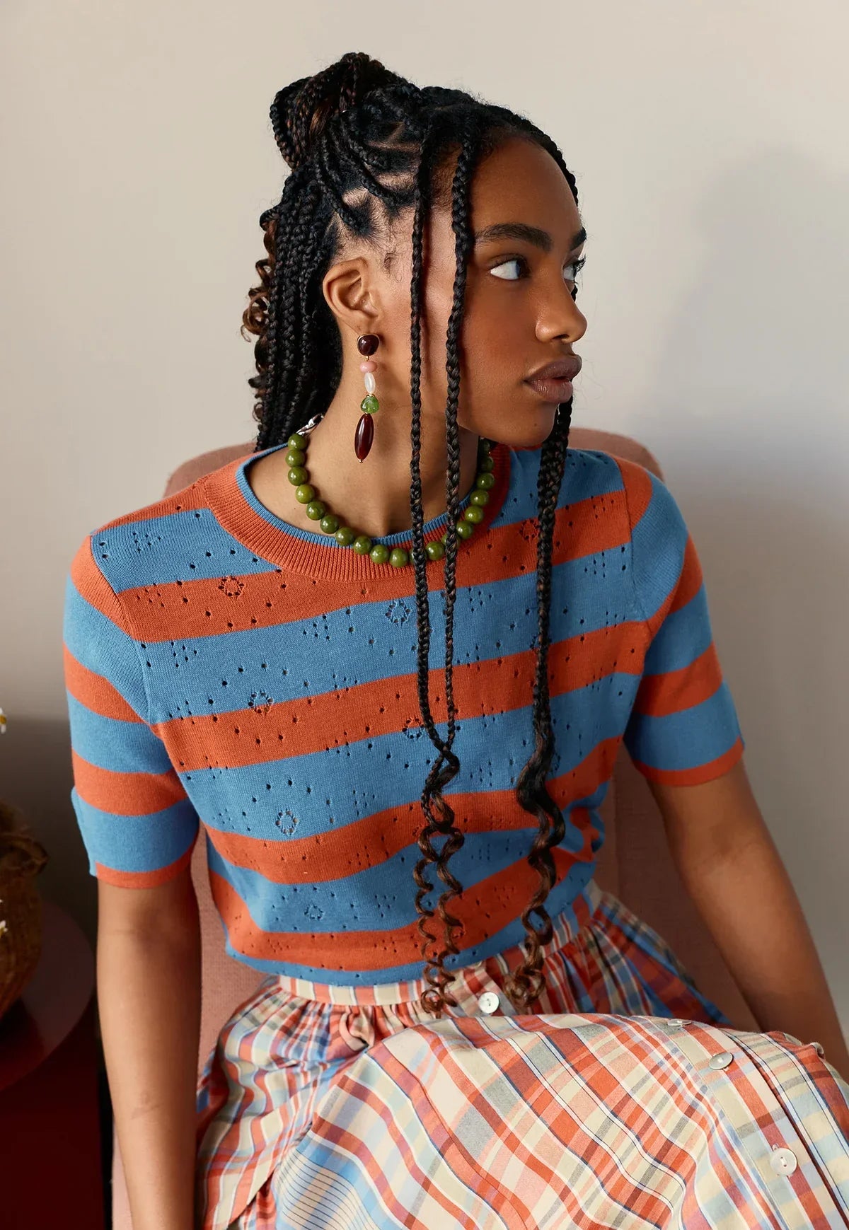 Woman wearing NANCYBIRD Rana Knit Tee in Terracotta Stripe with a matching plaid skirt.
