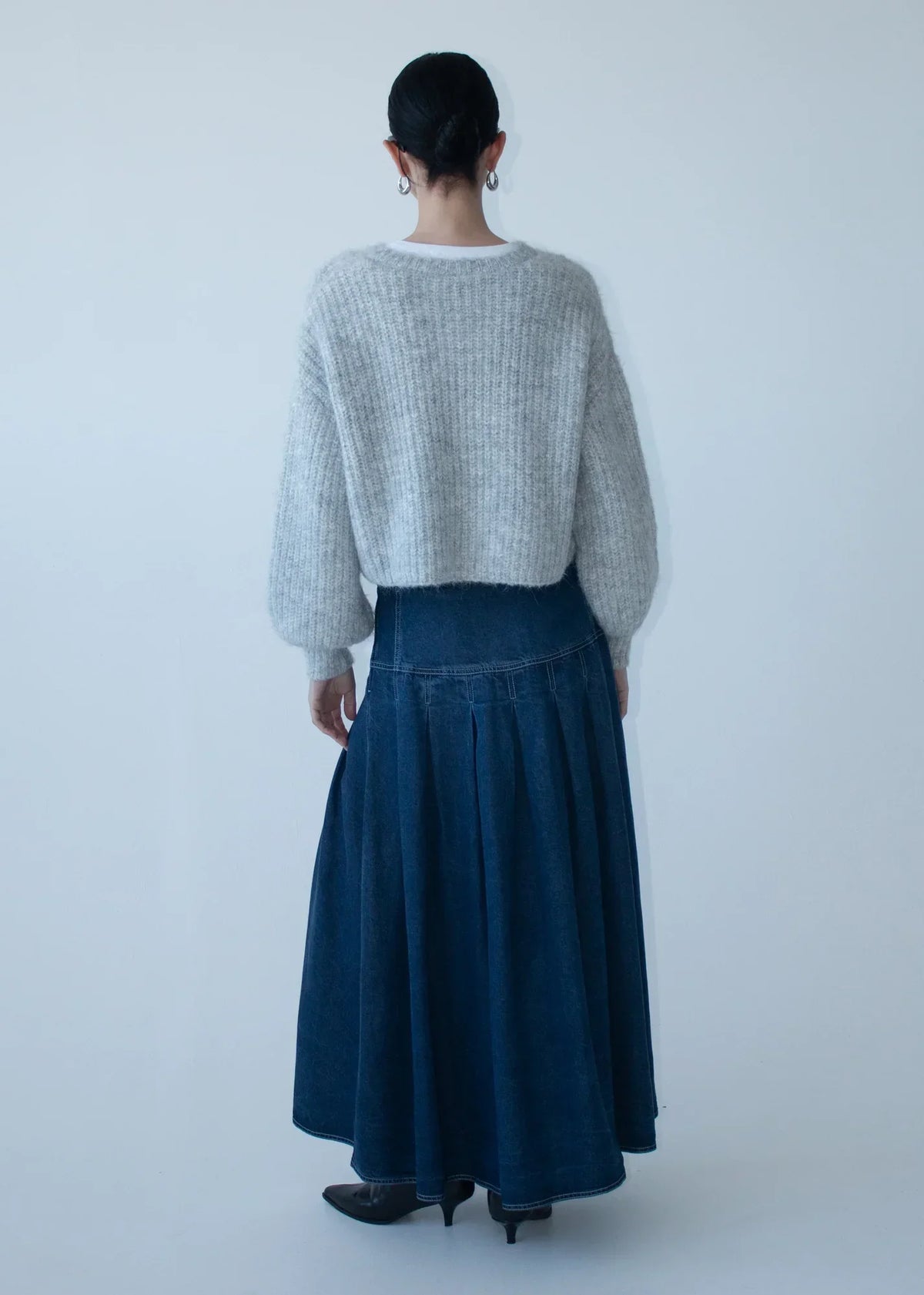 Rear view of a model wearing a grey sweater and STAPLE THE LABEL Roma Chambray Midi Skirt
