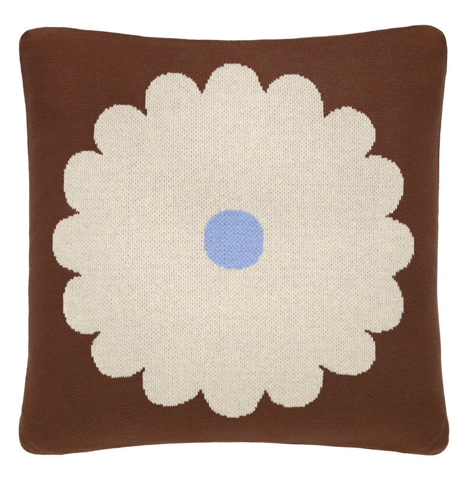 Brown throw pillow with a large cream flower and blue center.
