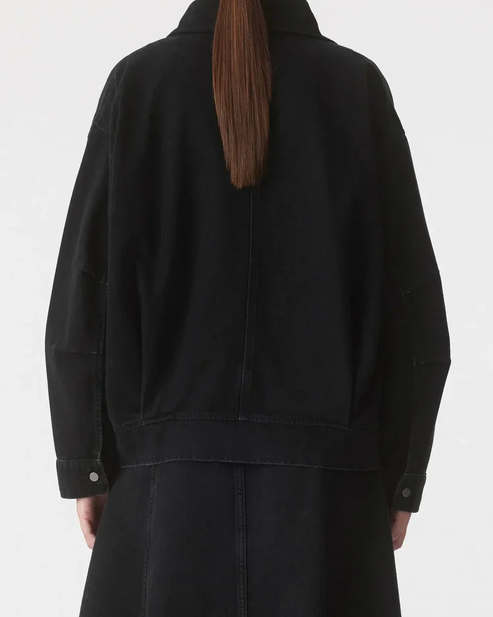 Black oversized denim jacket with button cuffs, back view on model