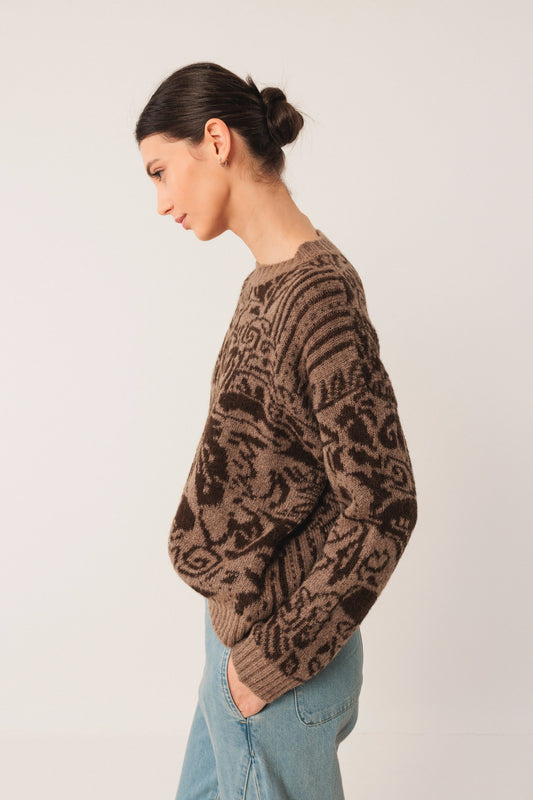 Brown patterned knit sweater with relaxed fit, paired with light blue jeans for casual style