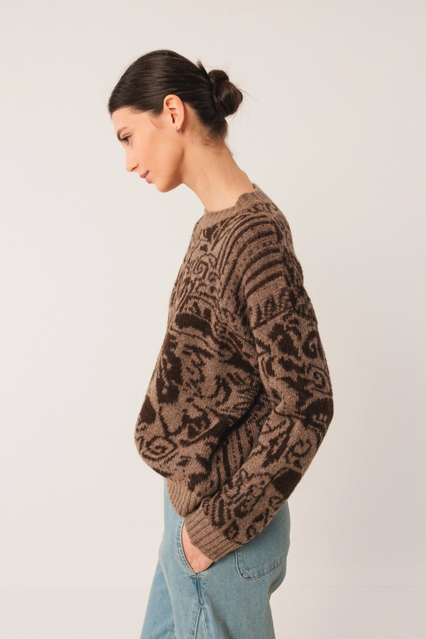Brown patterned knit sweater with relaxed fit, paired with light blue jeans for casual style