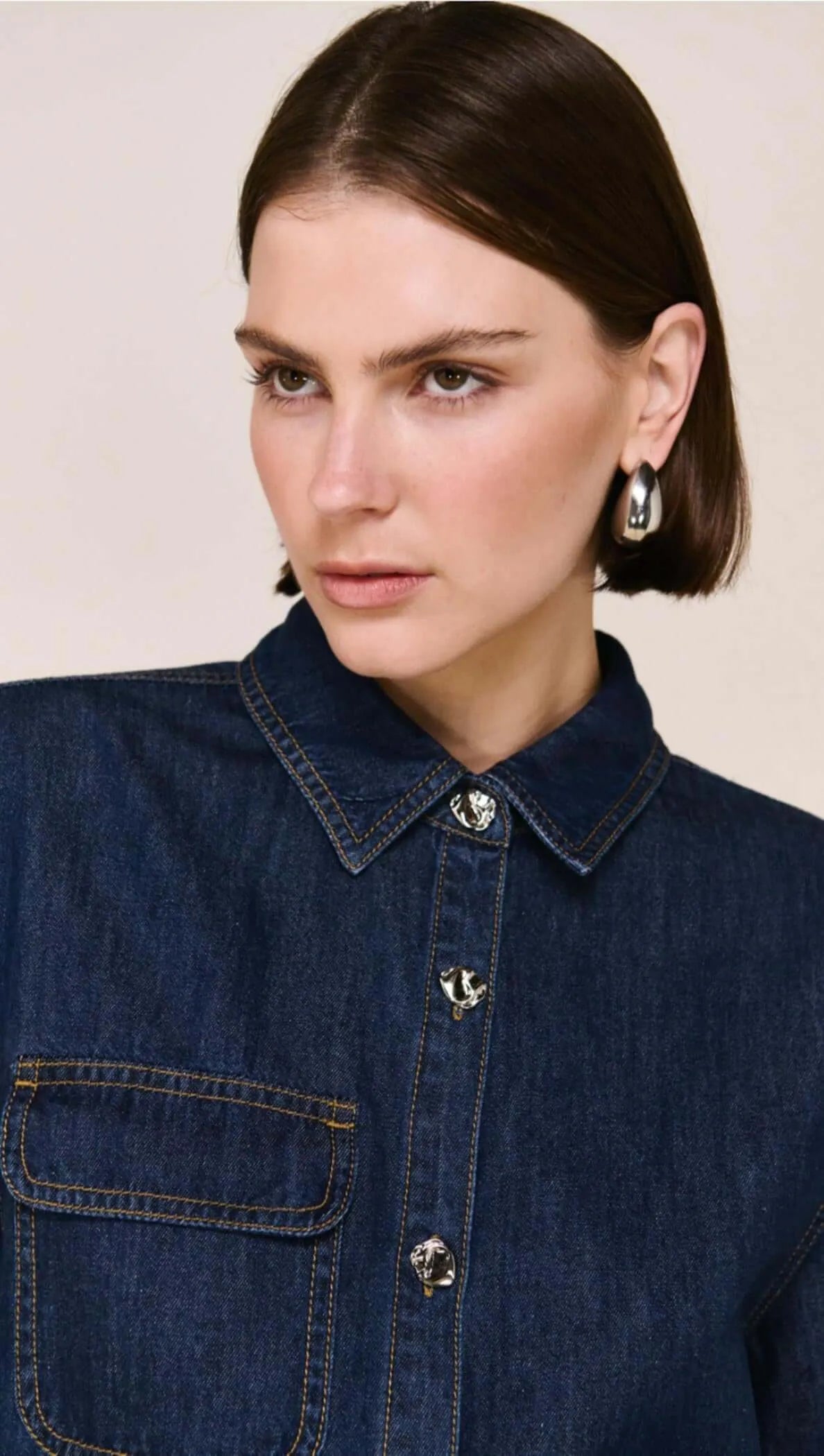 Woman in dark denim shirt with silver buttons, minimalist earrings, The Tartan Fox fashion