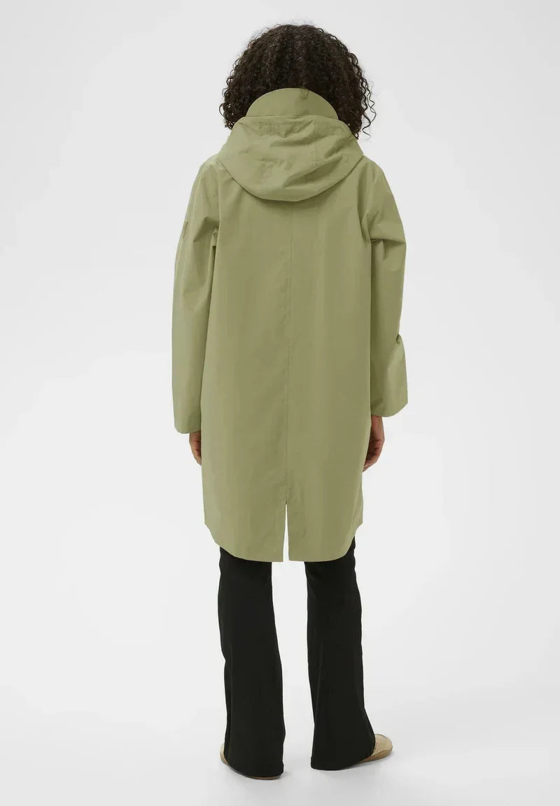 Olive green hooded raincoat with sleek design, paired with black flared pants for stylish weatherwear.
