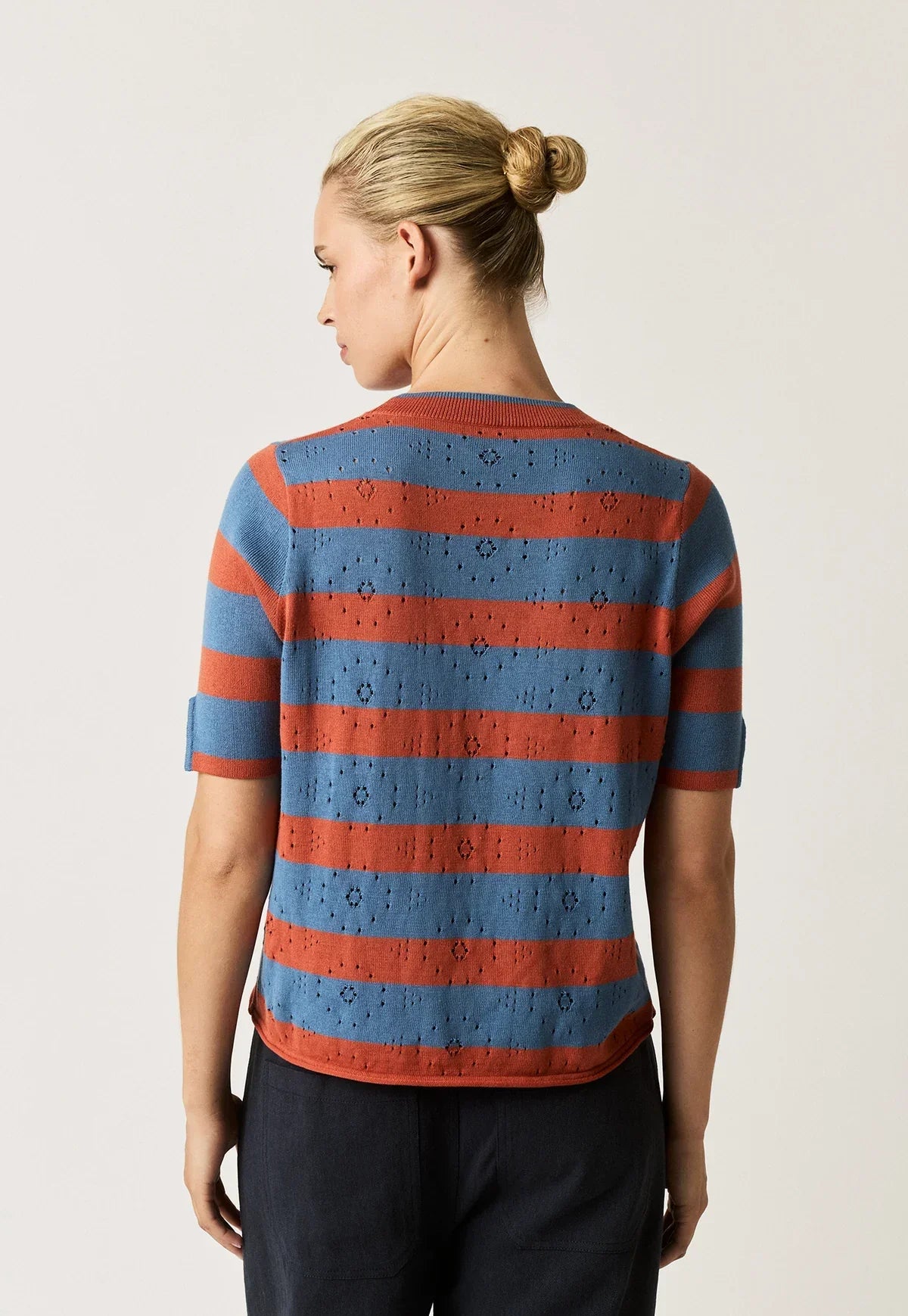 Back view of a woman wearing the NANCYBIRD Rana Knit Tee in Terracotta Stripe