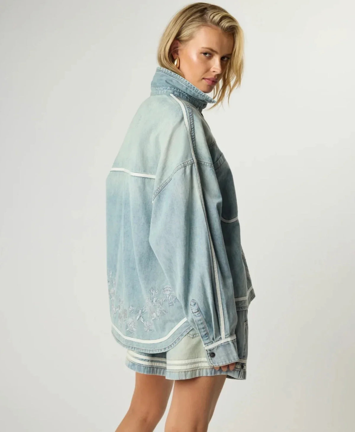 Woman wearing a ONE TEASPOON Folklore Embroidered Shirt in light wash denim.