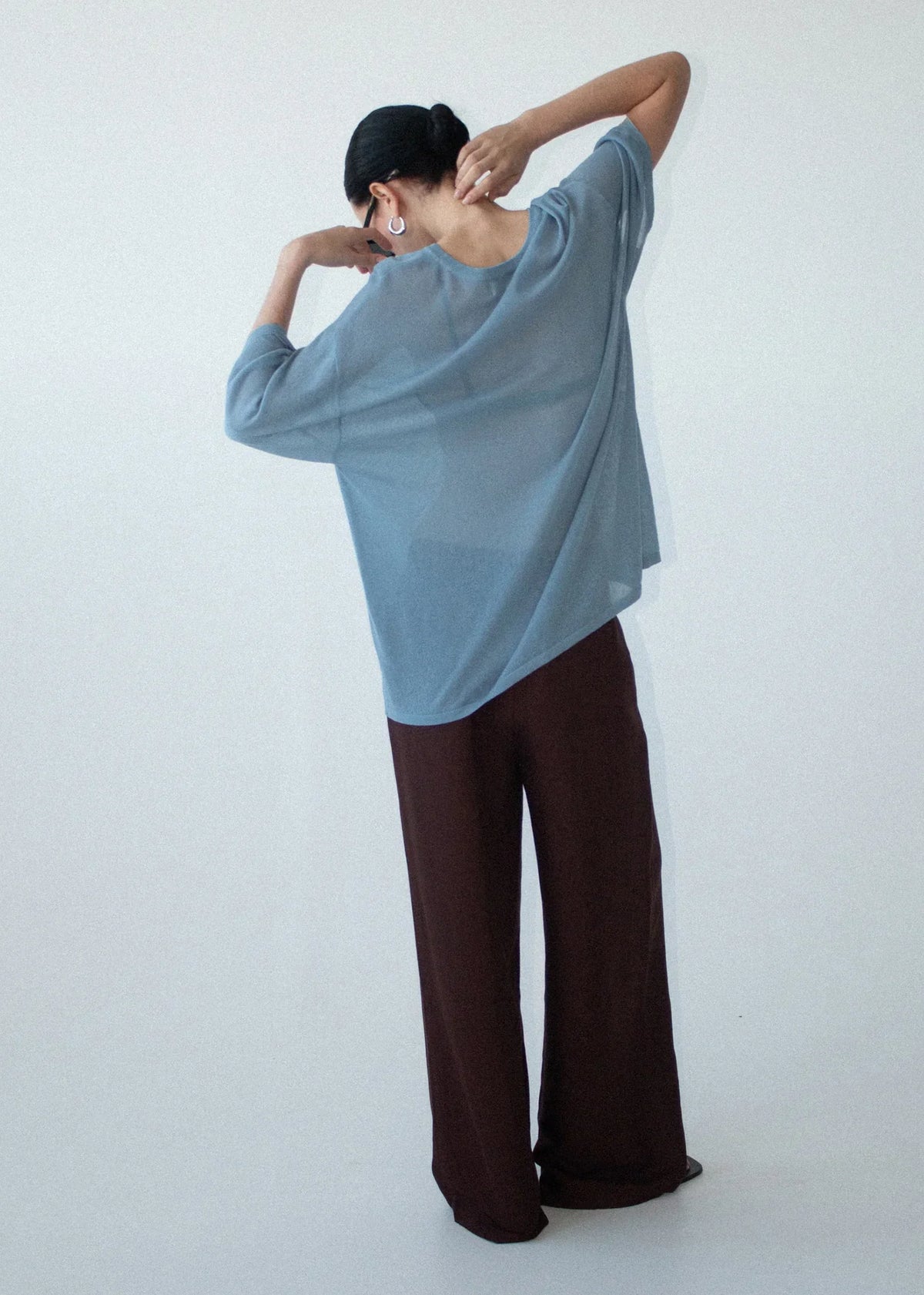 Woman wearing STAPLE THE LABEL Orla Oversized Knit Tee in dusty blue and brown trousers.