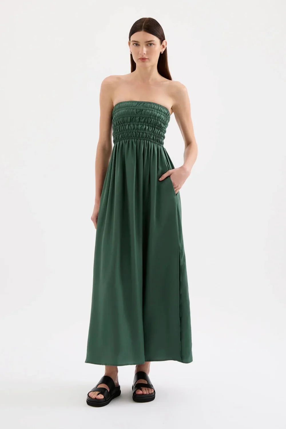 Woman wearing green strapless maxi dress with smocked bodice and black sandals