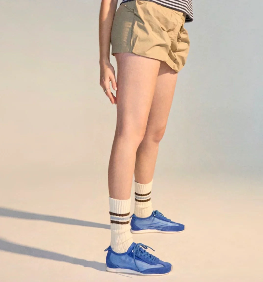 Rollie Cruz sneakers in cobalt mesh worn with white crew socks and khaki shorts.