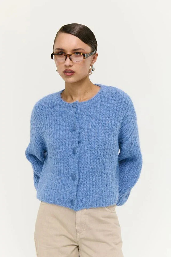Elowen Blue knitted cardigan with buttons, styled with beige pants and glasses