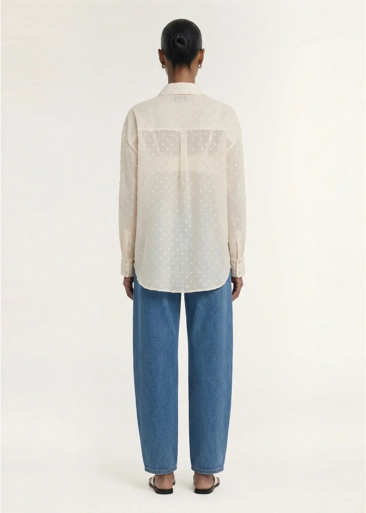 Back view of a woman wearing a STAPLE THE LABEL Etoile Oversized Shirt in Cream Spot and blue jeans