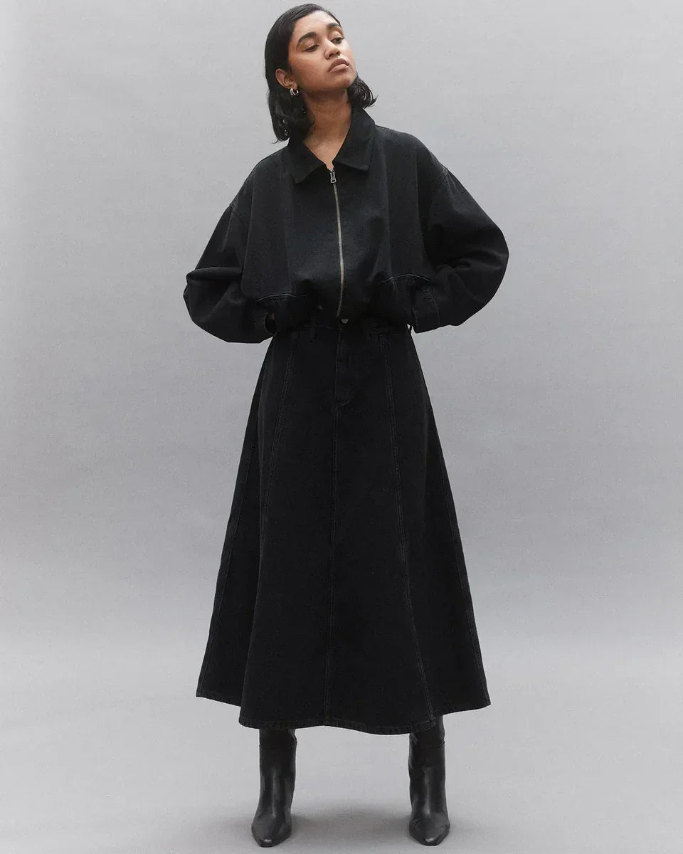 Black denim trench coat with zipper front and wide sleeves, styled with black boots for women's fashion