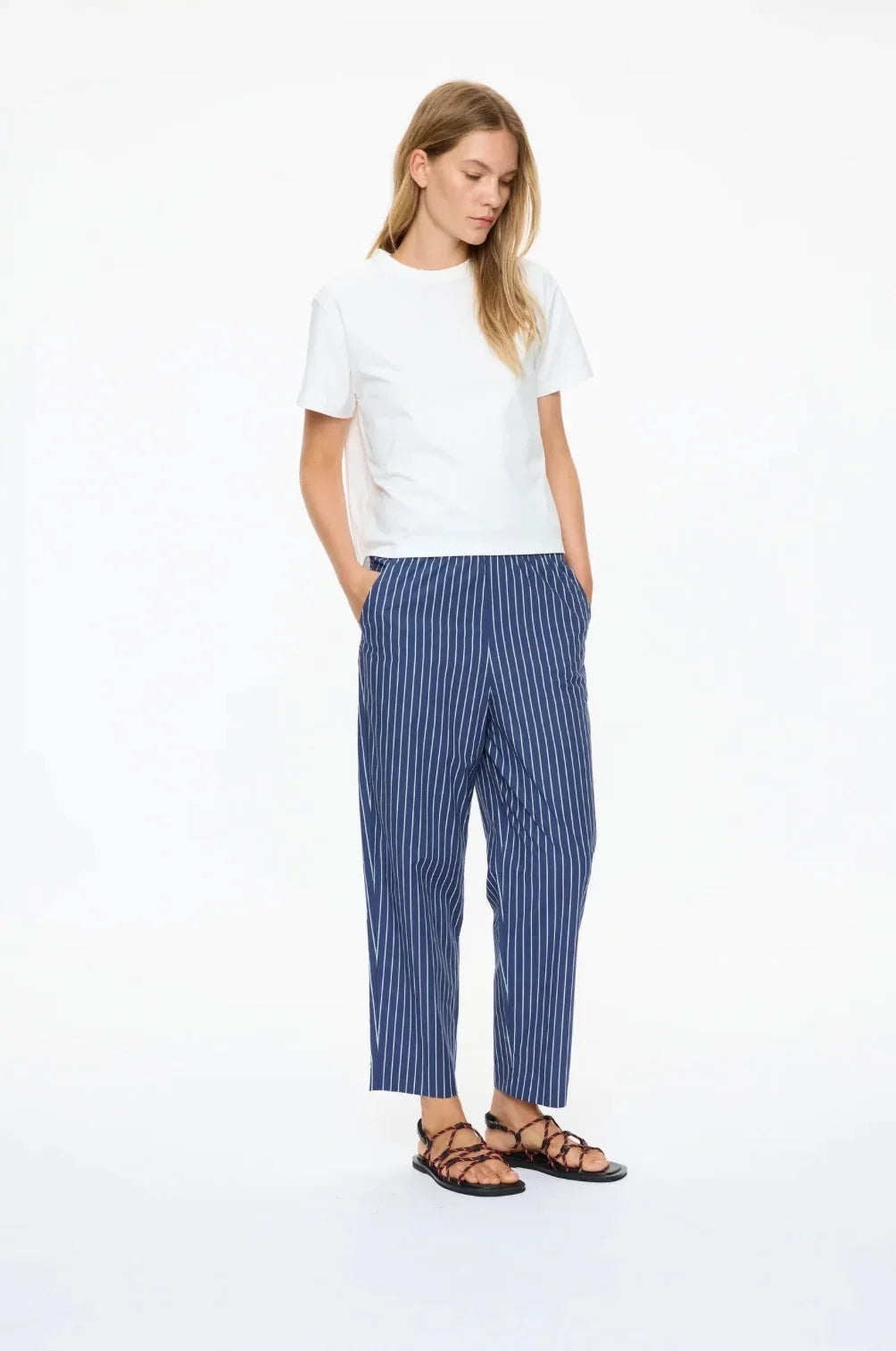 Woman wearing LMND Mimi Cropped Straight Leg Pants in blue and white stripes with a white t-shirt.