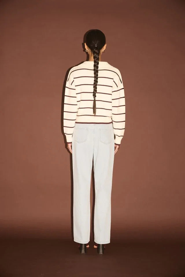 Woman in striped sweater and light wash jeans, back view, casual fashion outfit