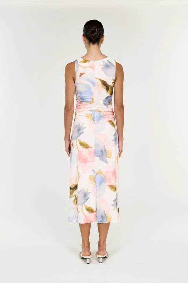 Rear view of a woman wearing a sleeveless midi dress with a pastel floral print.